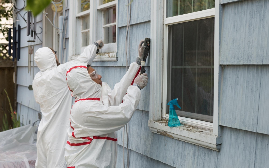 Professionals removing lead paint from siding