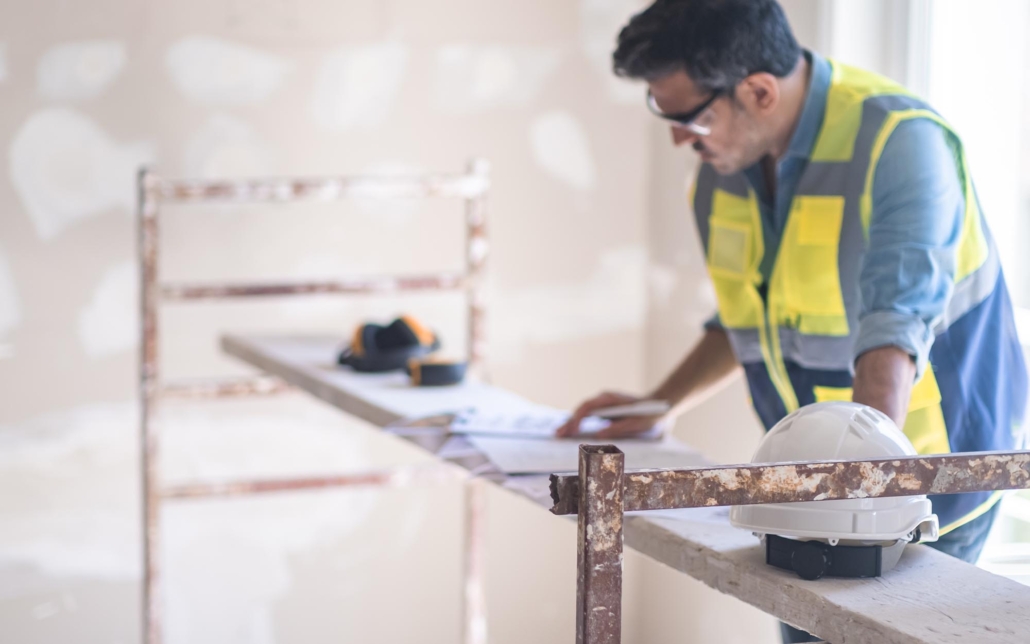 Worker looking at plans for house reconstruction