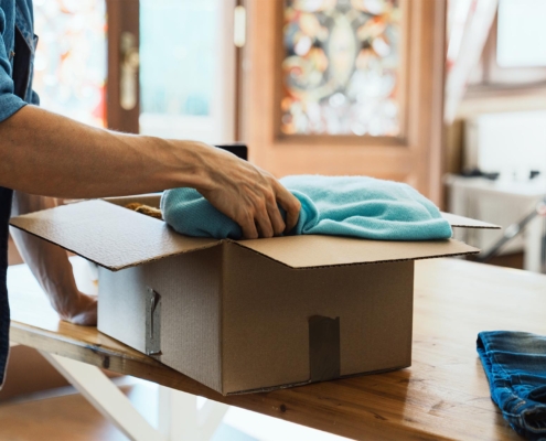 Worker packing up clothes in box