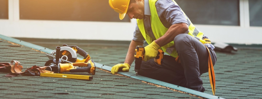 Worker redoing roof of commercial building Insurance roof replacement
