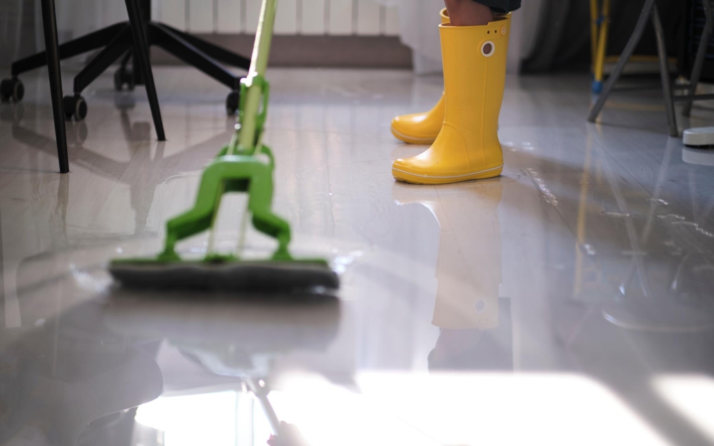 Water and Flood Restoration Help Worker cleaning up flooded water on office floor