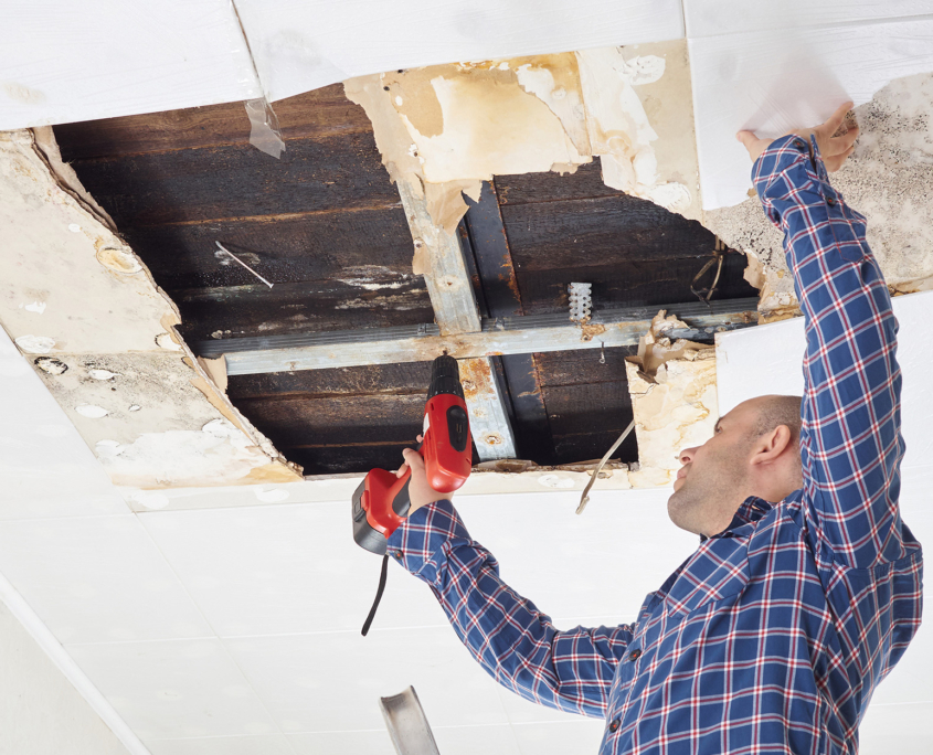 Man repairing collapsed ceiling