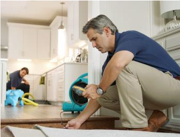 Professional water damage restoration Fair Oaks Ranch technician using moisture detection equipment in custom home